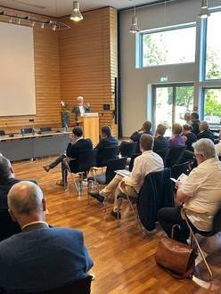 Quelle: Katholische Akademie der Erzdiözese Freiburg Viele Teilnehmende sitzen in der Aula und lauschen dem Referenten am Rednerpult.