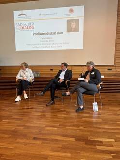 Quelle: Katholische Akademie der Erzdiözese Freiburg Zwei Frauen und ein Mann sitzen in der Aula und diskutieren.